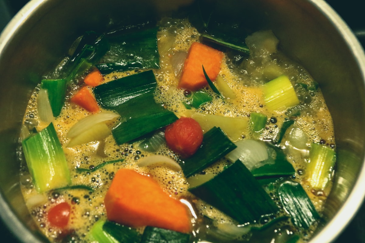 A bowl of chicken tinola with clear ginger broth, wedges of green papaya, and malunggay leaves