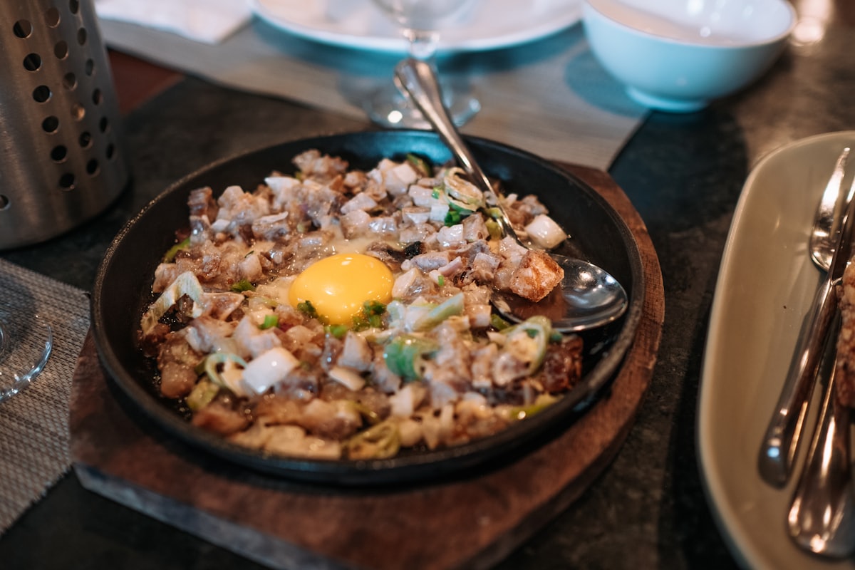 A platter of pancit bihon with thin rice noodles, shredded chicken, shrimp, cabbage, and carrots, topped with calamansi wedges
